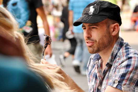 Khao San Road, Bangkok, Thailand. This man decided to go for it and eat a scorpion.  He was very nonchalant about it. Describing and pondering it to his companions with each bite.